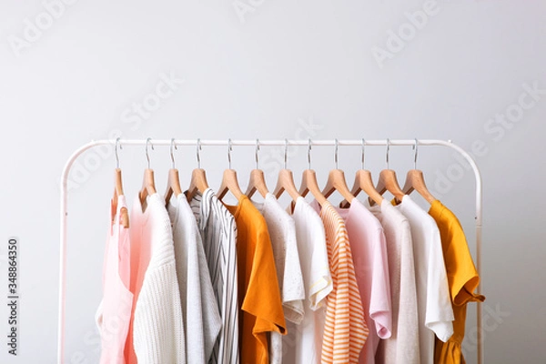Fototapeta fashion clothes on a rack in a light background indoors. place for text
