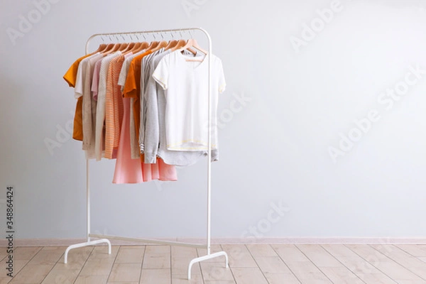 Fototapeta fashion clothes on a rack in a light background indoors. place for text