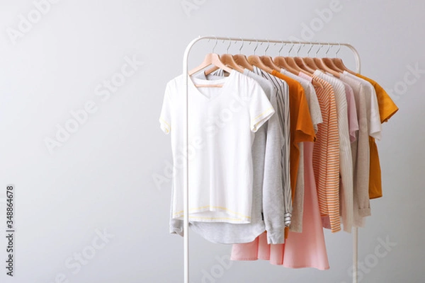 Fototapeta fashion clothes on a rack in a light background indoors. place for text