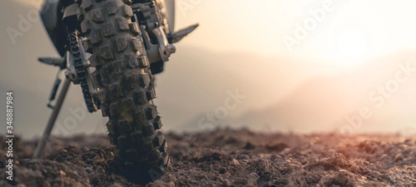 Obraz Part of a motocross wheel on a mound, with sunrise.copyspace for your individual text