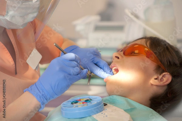 Obraz doctor cleans the canal in the tooth with an endodontic needle