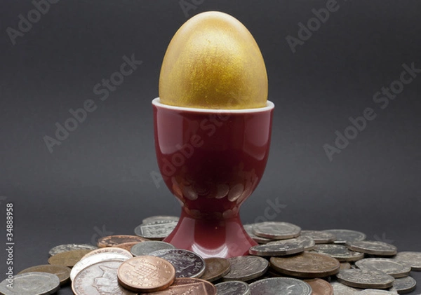 Obraz Egg in a red eggcup with Engish coins on a black background