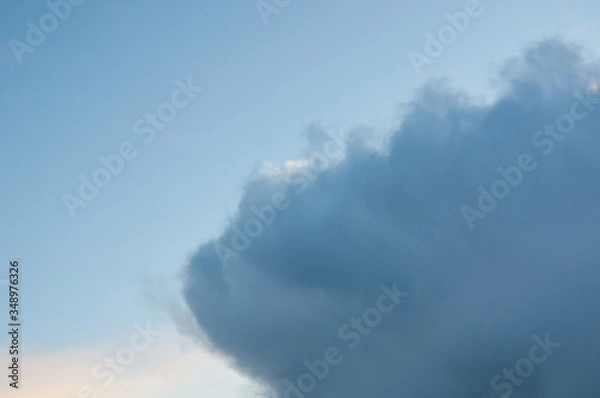 Fototapeta Rain clouds coming into blue sky in the atmosphere in the nature weather image.  Great for backgrounds and textures too.