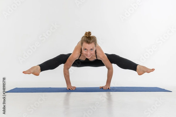 Fototapeta Sporty attractive young woman doing yoga practice on white background.