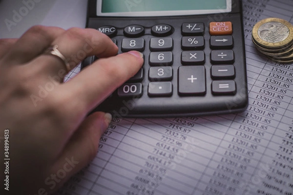 Obraz There is a calculator and coins on the table