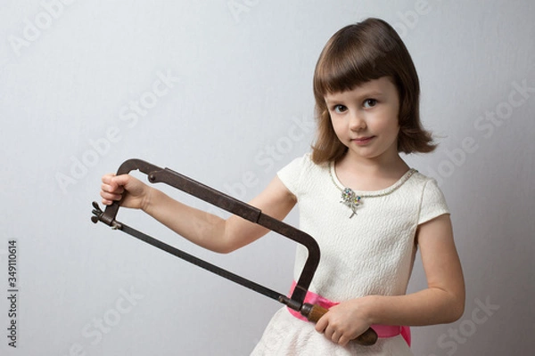 Obraz Girl holding a hacksaw in her hands