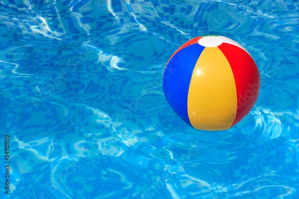 Fototapeta A colorful beach ball floating in a swimming pool