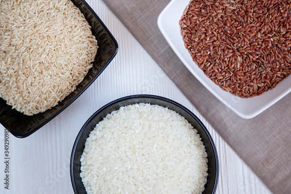 Obraz Different types of rice in cups on the table. White, brown and red.