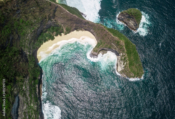 Fototapeta Top aerial view of the Kelingking Beach of Nusa Penida, Bali. Secluded, white sandy beach with turquoise waters enclosed by a steep cliff & headland.