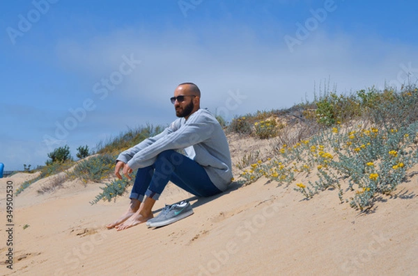 Fototapeta Chico sentado en la playa de Islantilla, Huelva, España. 