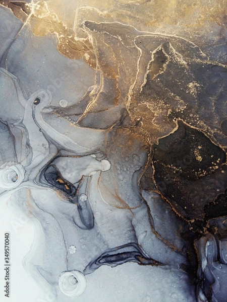 Fototapeta Luxury abstract fluid art painting in alcohol ink technique, mixture of black and grey paints.  Imitation of marble stone cut, glowing golden veins. Tender and dreamy design. 