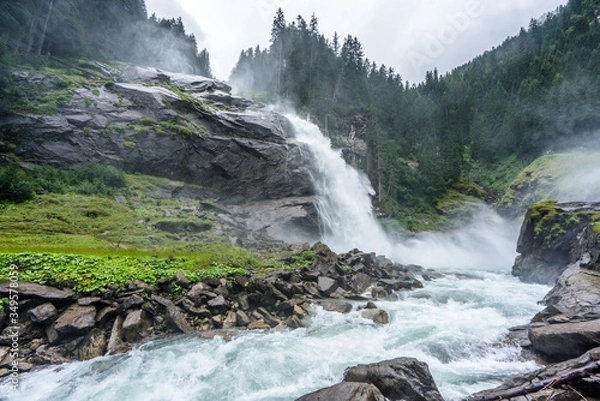 Fototapeta view of the Krimml Waterfalls from below on a wet and cloudy day in Austria. Majestic stream flowing at the highest waterfall of europe