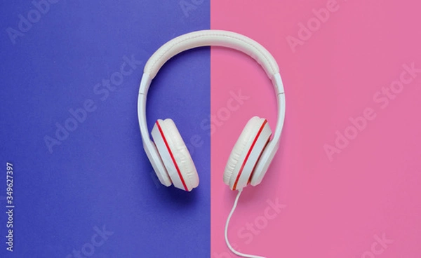 Obraz Classic white headphones on blue pink paper background. Retro style. 80s. Pop culture. Top view. Minimal Music Concept