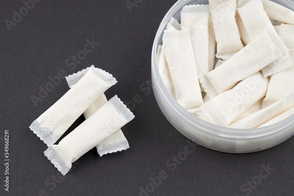 Obraz stack snus tobacco pouches over black background. copy space.