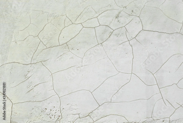 Fototapeta White concrete wall with cracks and scratches. Texture of scratched, old and worn wall close up.