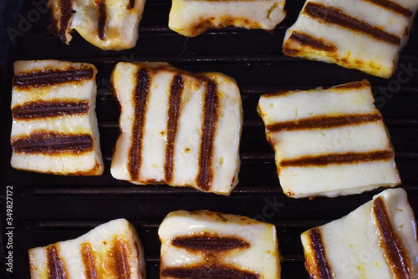 Fototapeta appetizing halumi cheese on a grill pan close-up.  fried cheese