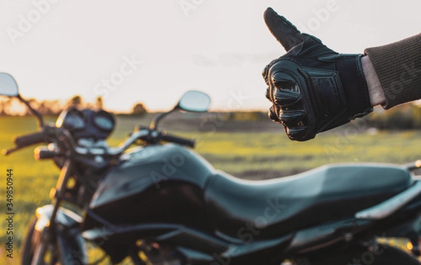 Obraz man shows his hand ok and holds his finger up on the background of motorcycles