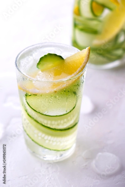Fototapeta Cold and refreshing infused detox water with lemon and cucumber in a glas. Homemade flavored lemonade