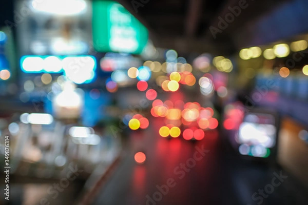 Fototapeta Blurred defocused lights of heavy traffic. Abstract blur image of night light bokeh on street. Blur traffic road with colorful bokeh light. Copy space of transportation and travel concept.