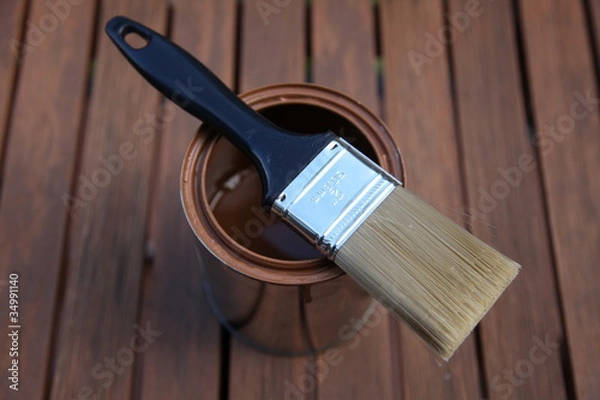 Fototapeta Clean paint brush, lying on a can, outside on patio