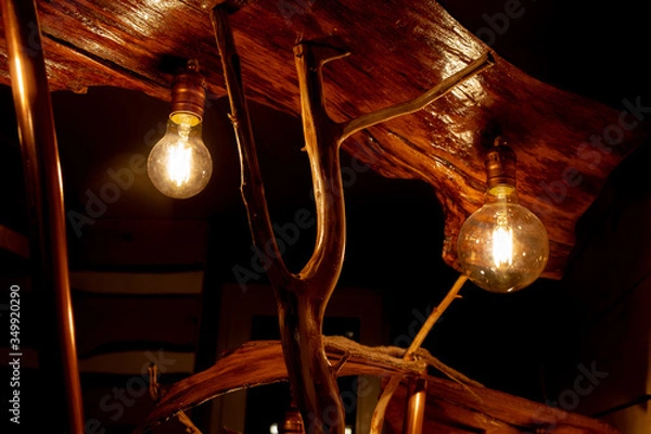 Fototapeta part of a handmade wooden floor lamp with LED lamps stylized as Edison lamps. Stylish piece of furniture