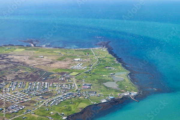 Fototapeta Keflavik, Iceland international airport aerial above high angle view of Reykjavik city from airplane window with beautiful blue ocean water