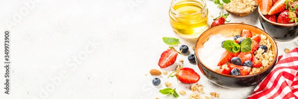 Fototapeta Greek yogurt granola with fresh berries on white stone table.