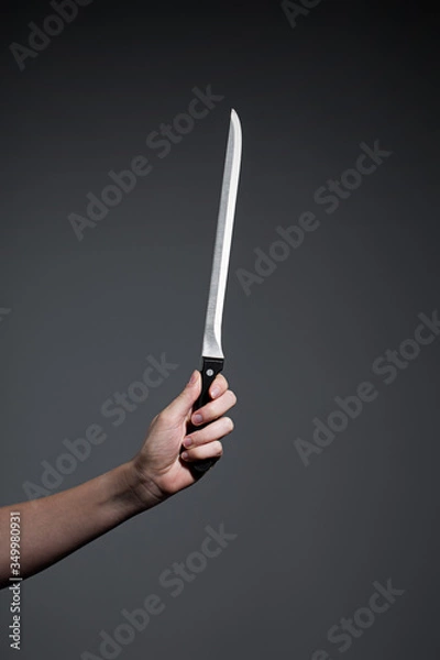 Obraz Hand holding a knife on grey background
