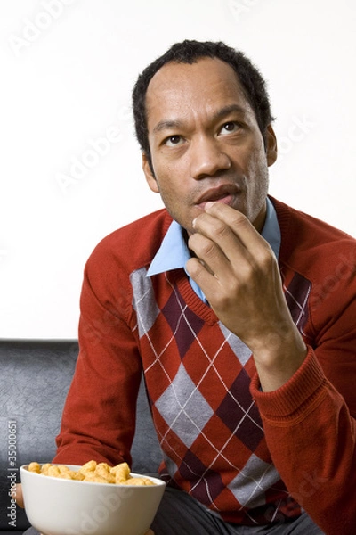 Obraz Man nibbling while watching television