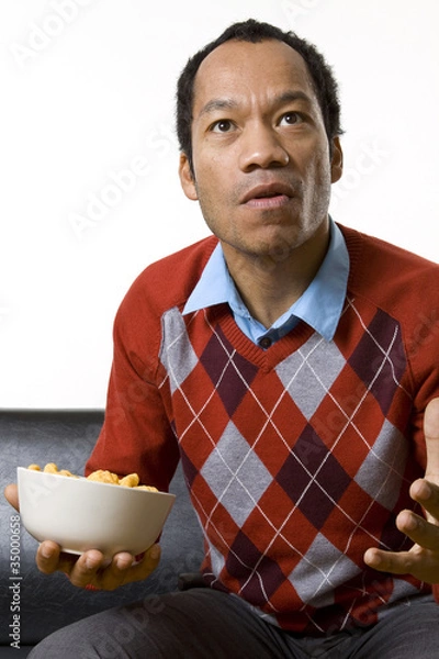 Obraz Man nibbling while watching television