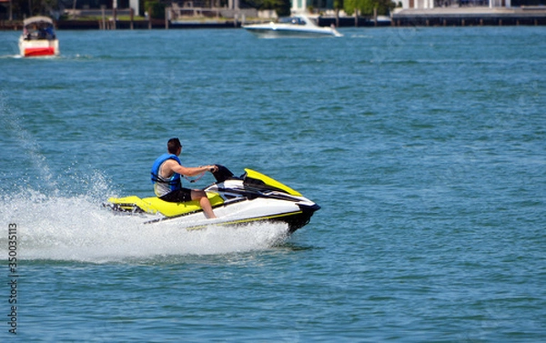 Obraz Man on a speeding yellow and white jet ski