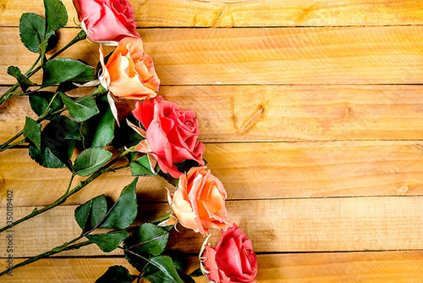 Fototapeta Handmade roses lie on a wooden background. Background layout with free text space.