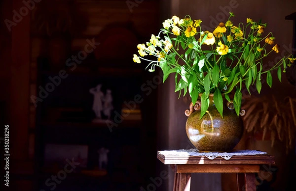 Obraz Bouquet of yellow wildflowers gelenium, echinacea in a conic ceramic vase on a small wooden table.