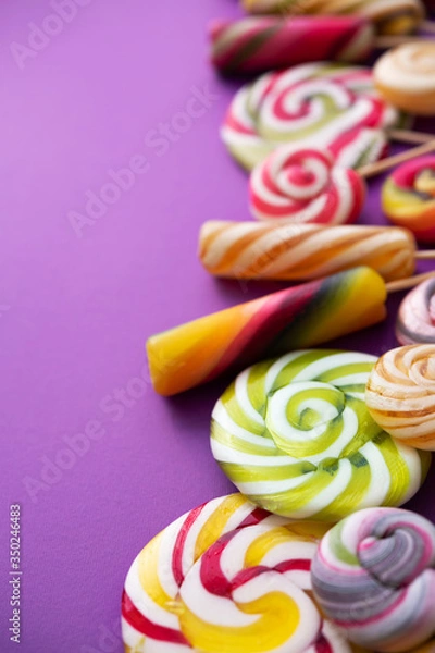 Obraz Lollypops kids food on a trend violet color background.