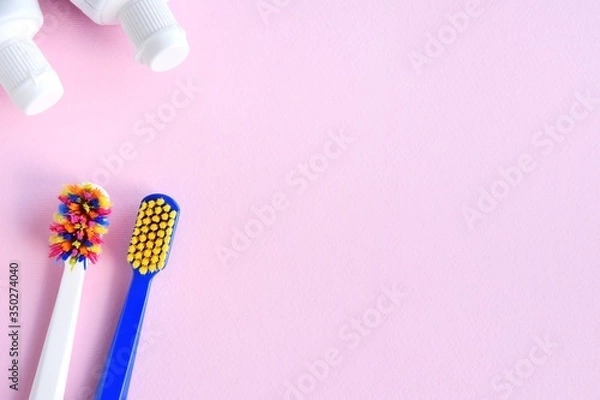 Fototapeta New and used toothbrush, dental floss and toothpaste on neutral pink background, selective focus, copy space. Healthcare concept. Replacing an old toothbrush with a new one, oral hygiene.