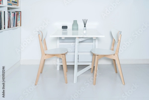 Fototapeta Dining tables and chairs and furnishings in a minimalist modern home. Working at home in a minimalist home.