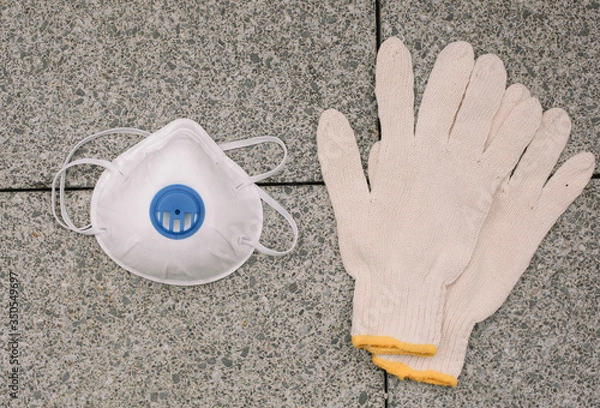 Obraz Mask, gloves are lying on the grey table background. Glass of water is standing on the grey background. Safety.