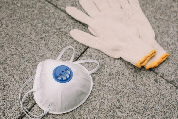 Obraz Mask, gloves are lying on the grey table background. Glass of water is standing on the grey background. Safety.