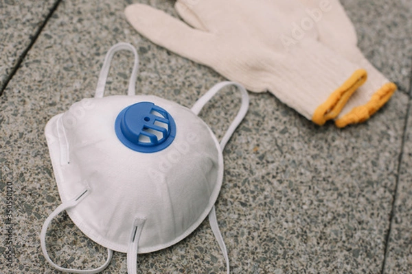 Obraz Mask, gloves are lying on the grey table background. Glass of water is standing on the grey background. Safety.