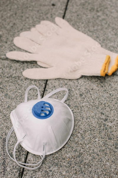 Obraz Mask, gloves are lying on the grey table background. Glass of water is standing on the grey background. Safety.