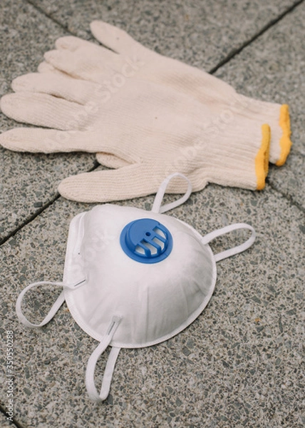 Obraz Mask, gloves are lying on the grey table background. Glass of water is standing on the grey background. Safety.