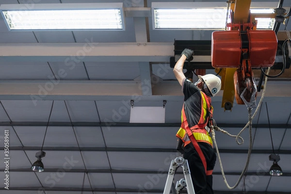 Obraz Engineers are inspecting hooks for lifting safety crane steel In the factory auto parts license Crane Operation