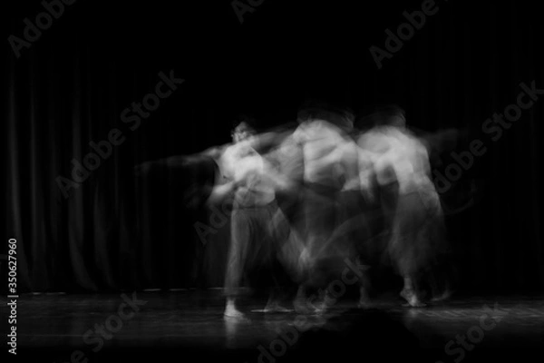 Fototapeta An artistic dancer in a theater shot with a slow shutter speed in order to achieve the desired motion blur.