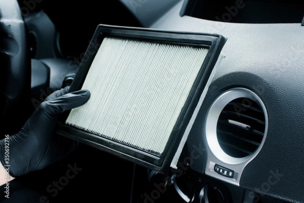 Fototapeta Technician holding pollen filter of car air conditioner. Maintenance and repair concept of the air conditioning and heating piping system. Workshop topic and car repairs. Automobile dashboard.