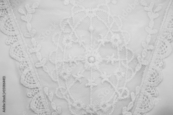 Fototapeta A background image of ivory-colored lace cloth. White lace on beige background.