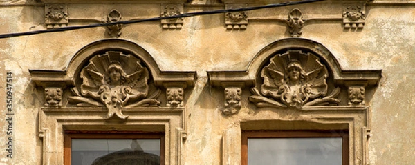 Fototapeta details of decorative ornament on plaster over the windows of an old building