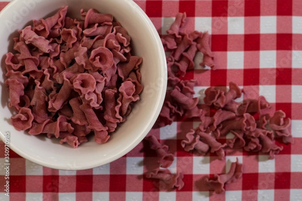 Fototapeta Raw italian pasta in a red and white towel background top view