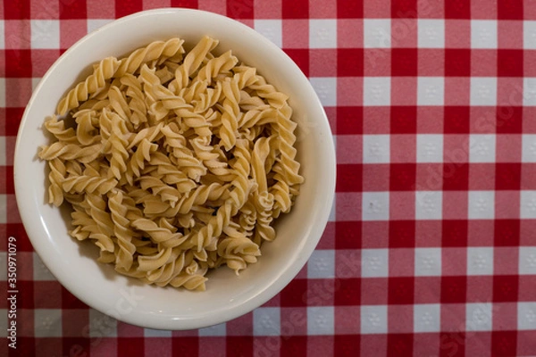 Fototapeta Raw italian pasta in a red and white towel background top view
