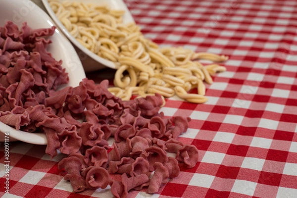 Fototapeta Raw italian pasta in a red and white towel background top view