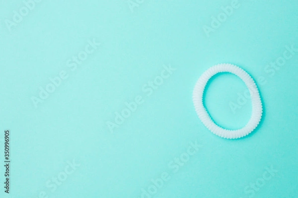 Obraz White hair band on a blue background with copyspace.